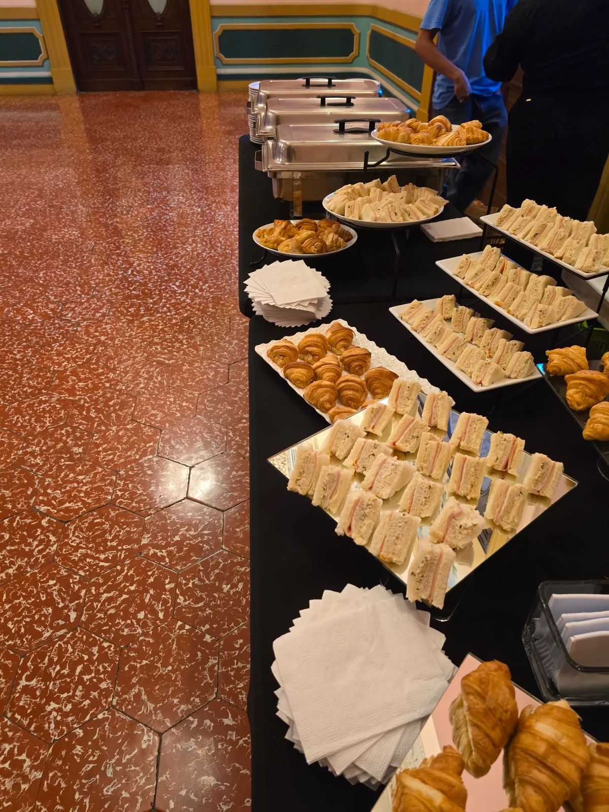 Buffet con sándwiches y croissants preparado por AUTÉNTICO para una celebración.